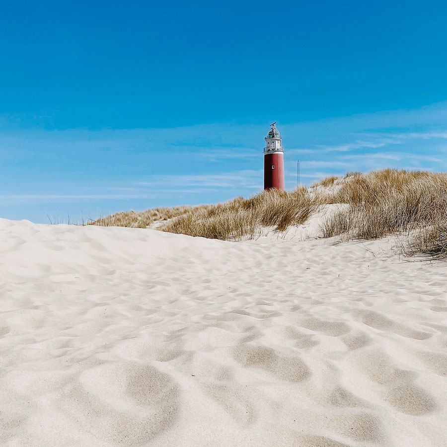 Weißer Sand und malerischer Leuchtturm auf der Insel Texel – Niederlande
