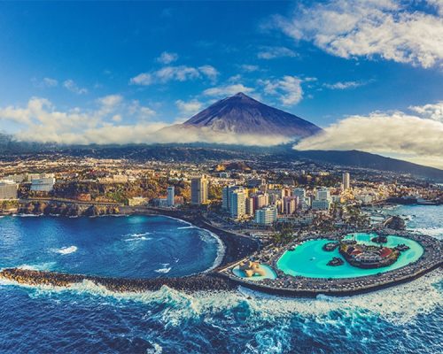 Puerto de la Cruz mit schwarzem Sandstrand und Teide im Hintergrund